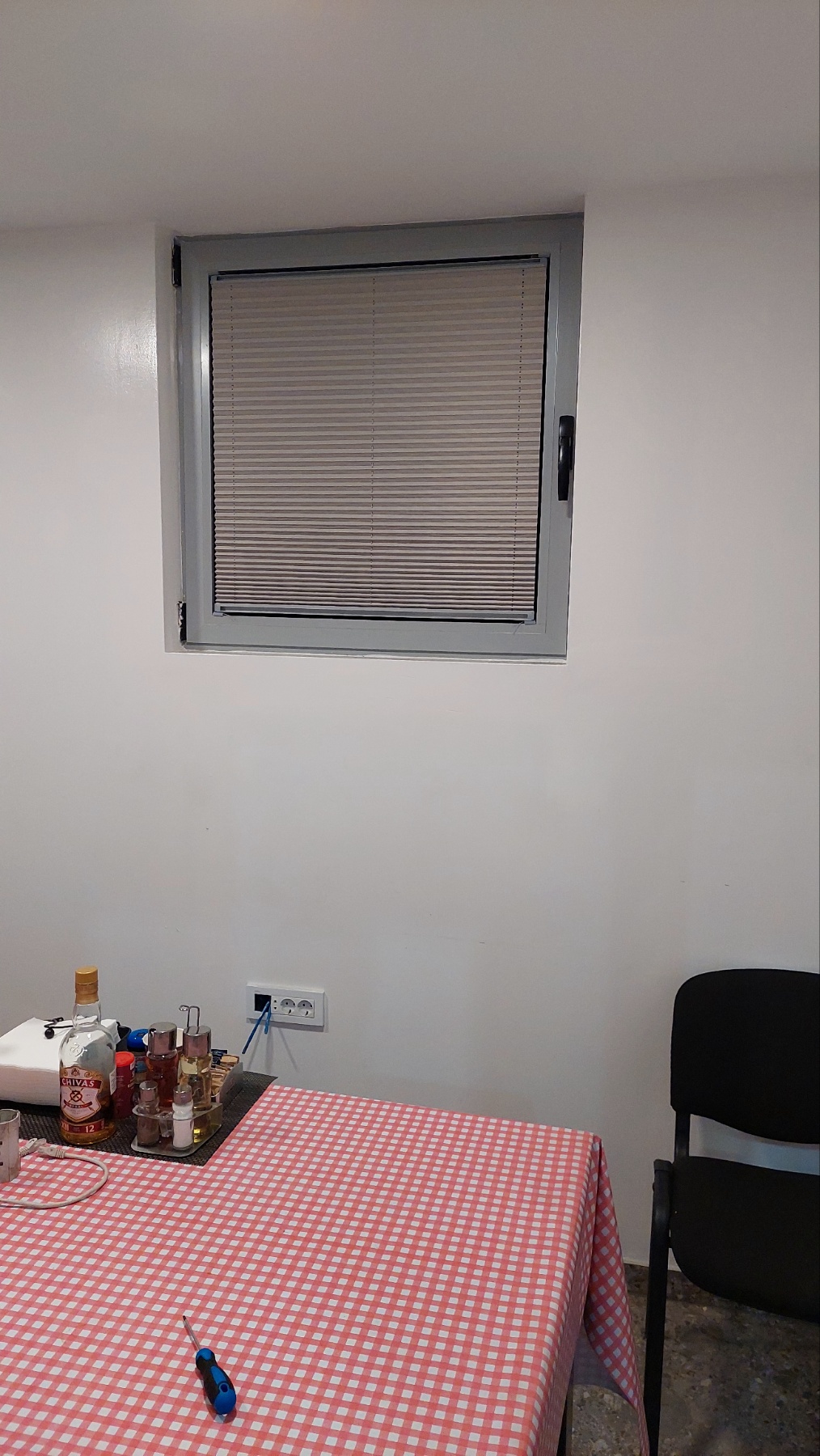 Aluminijumski venecijaneri bež boje na nagibnom prozoru u lokalu