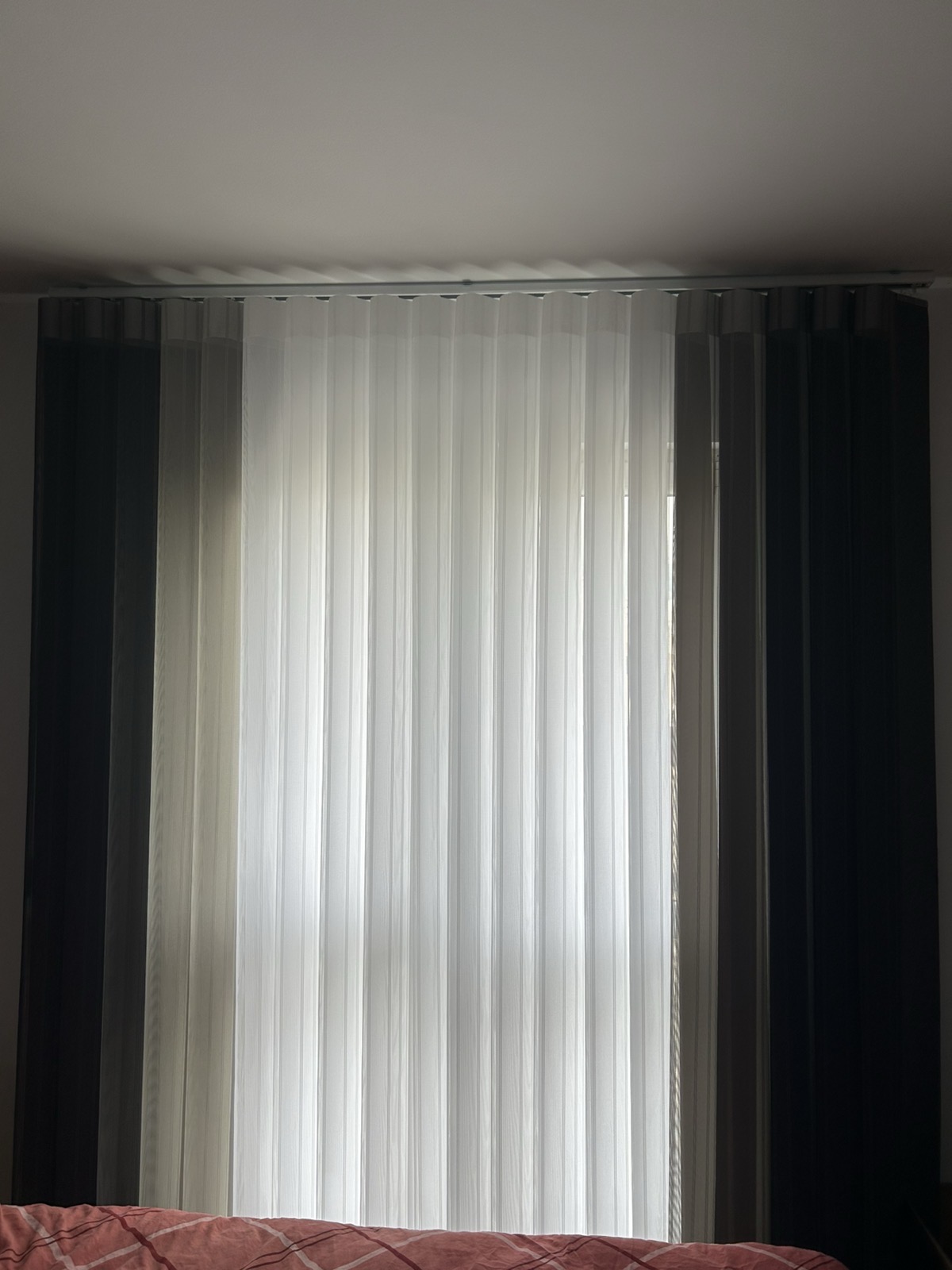 Dikey zavjese bijele i tamne tkanine u spavaćoj sobi
