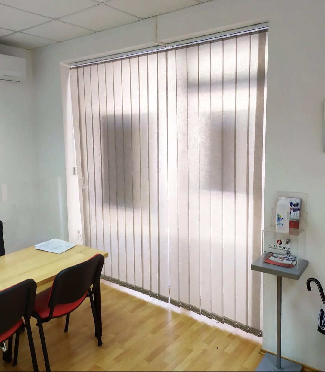 Dikey zavjese bež tkanine u kancelariji s drvenim stolom